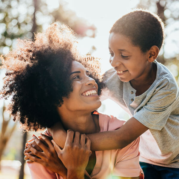 woman smiling with son giving hug