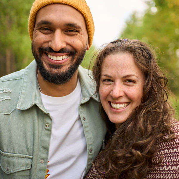 man and woman smiling together outdoors