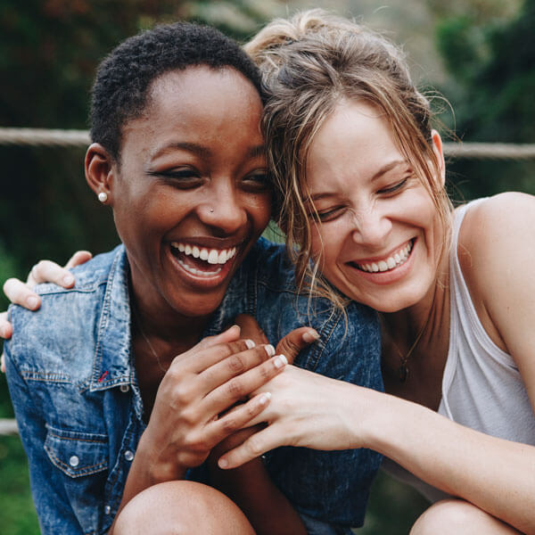 two women smiling together outdoors