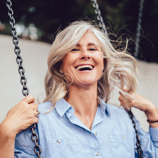 mature woman smiling on swing